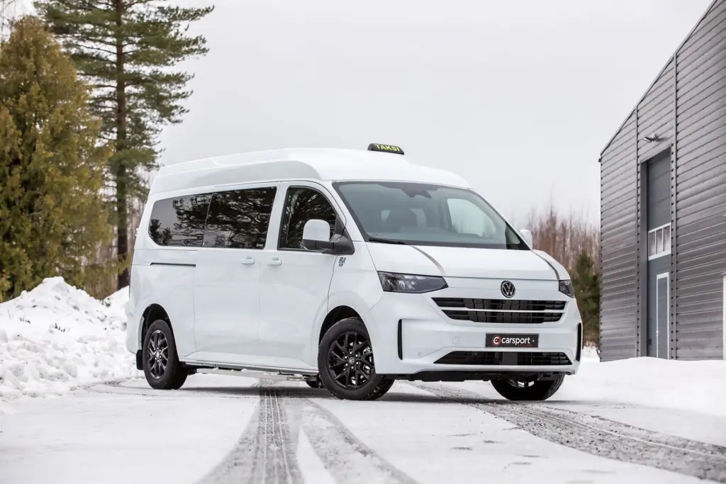 Valkoinen Volkswagen T7 taksi talvisessa maisemassa Carsport Design kattokorotuksella.