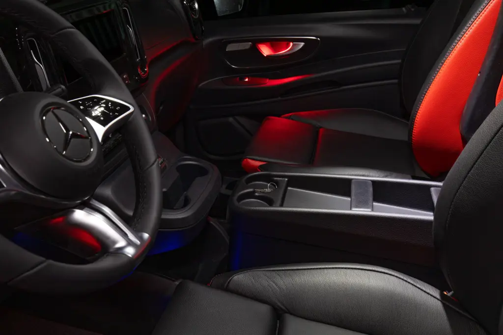 Viton etuistuimien väliin asennettu kannellinen säilytyslaatikko, jossa pullopaikat